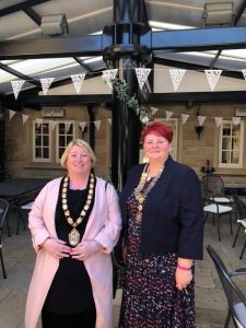 Mayor Mary Kelly stood with deputy Mayor in an outdoor eating space with bunting, both smiling.