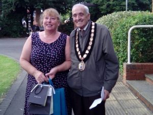 Mayor John Walker stood to the right of a lady holding gift bags, both smiling.